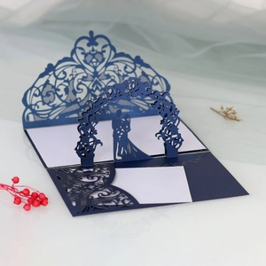 Detail of 3D laser-cut wedding invitation showing bride and groom silhouette in navy blue
