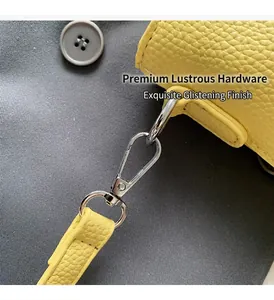 Detail of yellow lychee leather texture with silver swivel metal hook on handbag