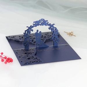 Macro detail of laser-cut 3D wedding invitation with floral arch and navy paper