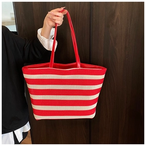 Dettaglio della borsa tote intrecciata a righe rosse e crema con trama traspirante
