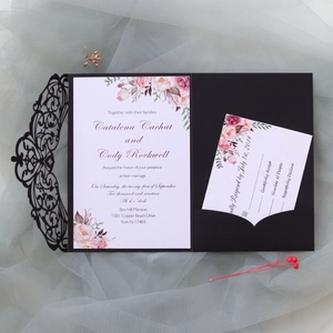 Detail of laser-cut wedding invitation with floral inner card and RSVP set on tulle