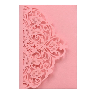 Detail showing laser-cut lace floral and butterfly patterns on pink wedding invite paper