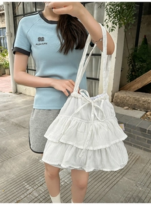 Close-up of a white layered ruffles shoulder bag with elegant drawstring and bow detail