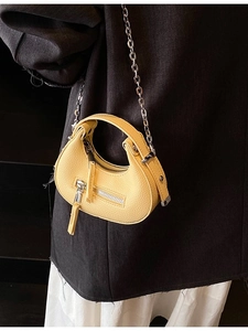 Yellow pebble leather mini half-moon bag with silver chain strap shown on model