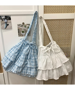 Detail of blue plaid and white ruffle tote bags with sweet decorative bow ties