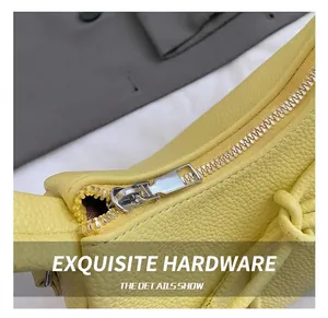 Detail showing silver metal zipper and yellow litchi texture leather stitching on the bag