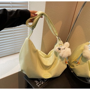 Dettaglio della borsa hobo a quadretti verde chiaro con logo e ciondolo a forma di coniglio