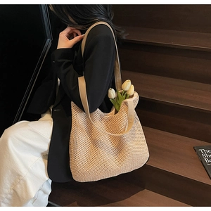 Close-up of large woven tote bag with leather straps and tulip flower decoration