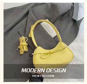 Detail of yellow lychee pattern leather bag with side bow and adjustable strap