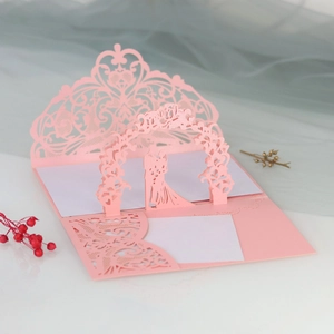 Detail of laser-cut 3D pop-up wedding invitation with heart pattern and couple silhouette