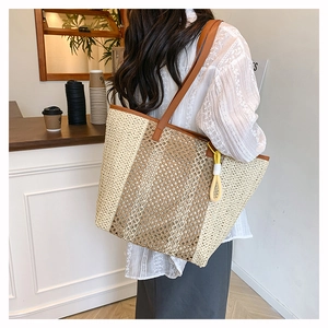 Close-up of a large woven straw beach tote bag with leather straps and knot detail