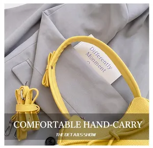 Detail of a yellow dumpling bag featuring a decorative bow and comfortable handle