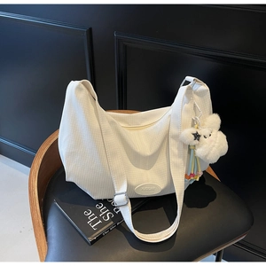 Dettaglio della borsa Hobo bianca con tessuto testurizzato, logo del marchio e ciondolo coniglio