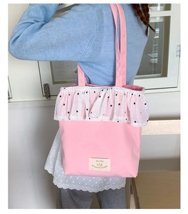 Pink canvas tote bag with white lace ruffle edges shown on model in a bright setting