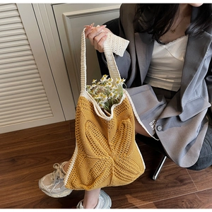 Detail of handmade crochet tote bag featuring a large yellow 3D heart pattern and fringe