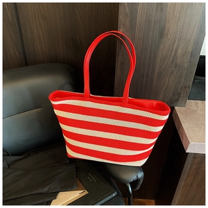 Dettaglio della borsa tote in maglia a righe rosse e bianche con manici in ecopelle