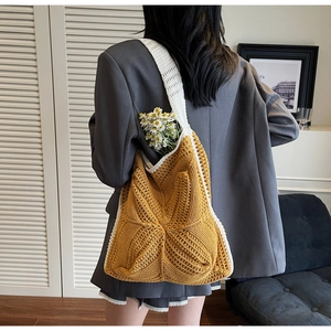 Detail of yellow and white hand-crocheted shoulder bag with star pattern on model