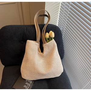 Detailed close-up of a woven tote bag with tulip flowers on a vintage blue chair