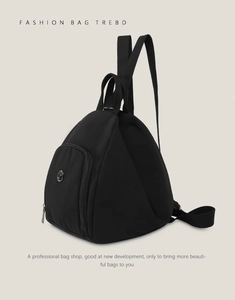 Detail of black nylon backpack featuring triangular silhouette and metal zipper pocket