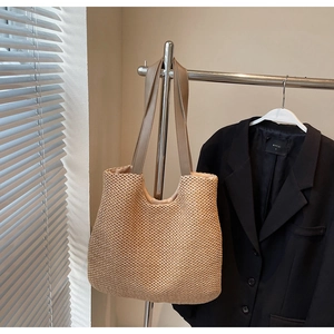 Detailed close-up of woven tote bag texture with premium brown leather shoulder straps