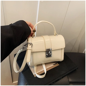 Detail of off-white leather shoulder bag with silver square buckle and top handle