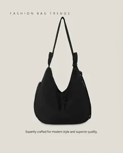 Detail of minimalist black nylon hobo bag with sleek zipper and adjustable shoulder strap