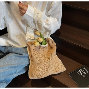 Detail of hand-crocheted tote bag featuring two-tone flower patterns and rustic fringe style