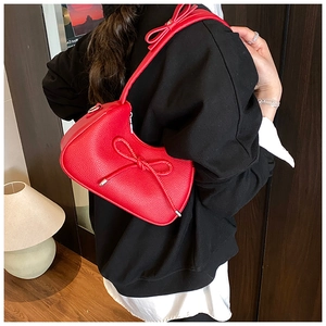 Detail showing red hobo bag with bow accents in premium lychee pattern leather