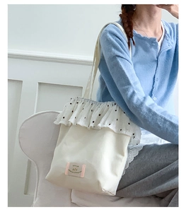 Close-up of canvas tote bag with floral ruffle trim and pink label for casual style