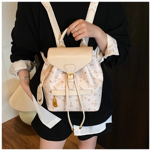 Detail of cream women's backpack featuring teddy bear prints and stylish buckle closure