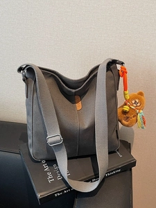 Sac seau minimaliste en toile grise avec pendentif ours en peluche et bandoulière réglable
