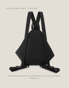 Detail view of the black triangular backpack showing back zipper pocket and straps
