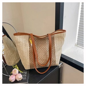 Detail of woven straw tote bag featuring mesh patterns and premium brown leather trim