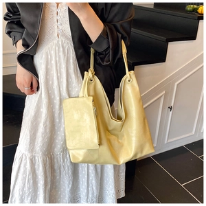Detail view of light yellow tote bag with matching mini pouch on side metal ring