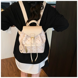 Detail of cream faux leather backpack with cartoon bear prints and golden metal lock buckle