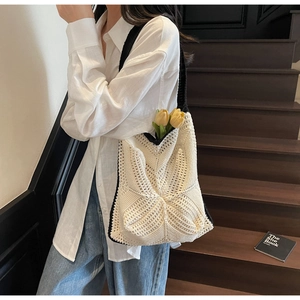 Detail of crochet tote bag with geometric hollow patterns and chic contrast borders