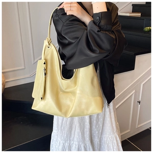 Detail of light yellow tote bag with knotted strap and small detachable zipper pouch