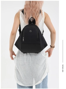 Detailed back view of a black geometric nylon backpack showing texture and side zipper
