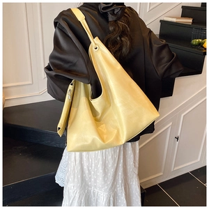 Detail of a soft pale yellow leather tote bag with a matching detachable zipper pouch