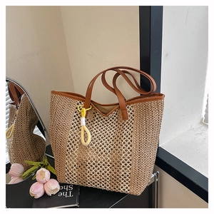 Detailed woven texture of straw beach tote bag with leather handles and colorful tassel