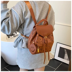 Detail of caramel brown backpack with cartoon bear print and large leather charm