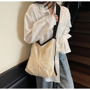 Detail of hand-crocheted hollow star patterns on the beige woven shoulder bag