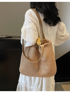 French style woven straw tote bag with wide straps and tulip detail for beach travel