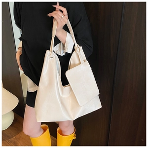 Detail of cream white leather tote bag with a matching small zipper pouch on handle