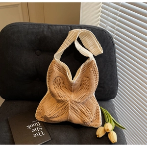 Detail of handmade crochet shoulder bag featuring two-tone geometric pattern and wide strap