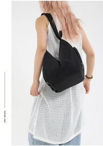 Minimalist black large capacity shoulder bag shown on model for size and drape reference