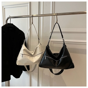 Close-up of hobo shoulder bags in black and white pebbled leather with metal zipper details