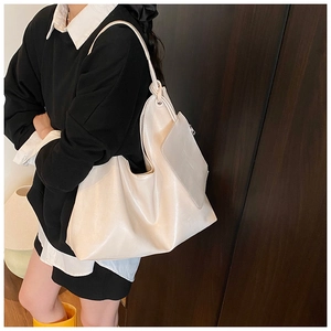 Detail of cream-white oversized bucket bag with soft leather texture and small pouch