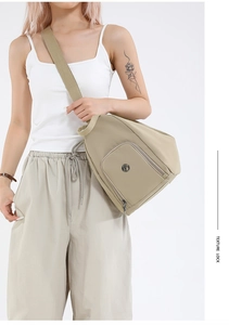 Detail of khaki sling bag with adjustable wide strap and smooth zipper pocket
