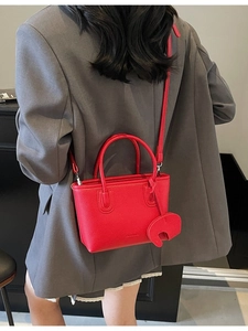 Red lychee pattern mini tote bag with elephant charm on model in gray blazer